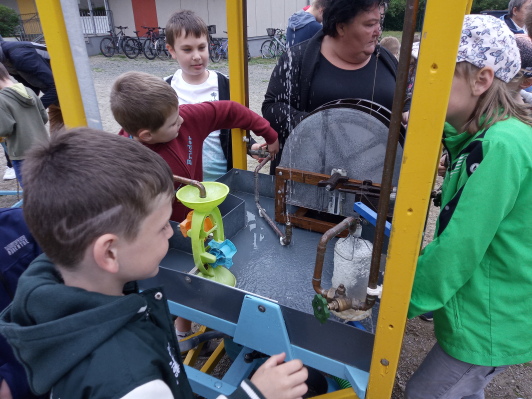 Die Kinder staunen über einen künstlichen Wasserkreislauf